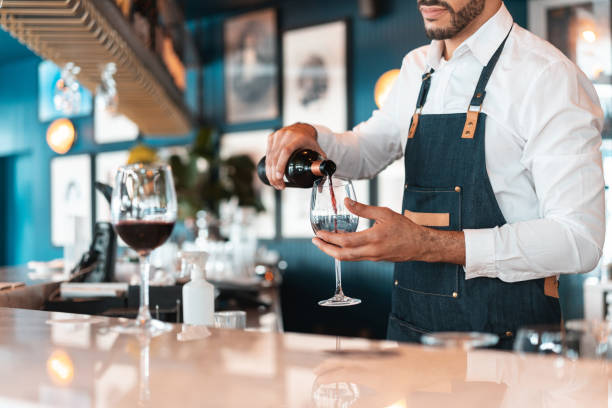 sommelier serwujący czerwone wino w luksusowym hotelowym barze - champagne champagne flute pouring wine zdjęcia i obrazy z banku zdjęć