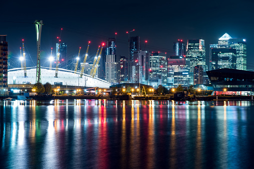 Night View of Millennium Dome (O2 Arena) and Canary Wharf District Skyscrapers in the City of London, UK.