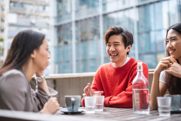 istock Three Chinese friends talking and drinking at a cafe 1193198681