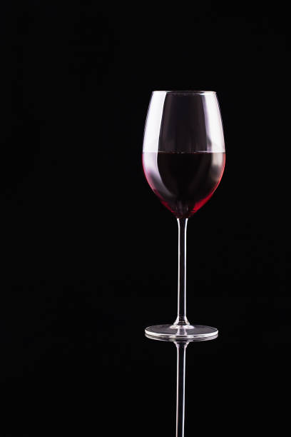 Glass of red wine on black background. Aromatic wine. Strict style. Wine on the dark stock photo