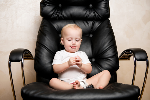 the child sits in an office chair, sticking out his tongue. With him on the armchair are text stamps