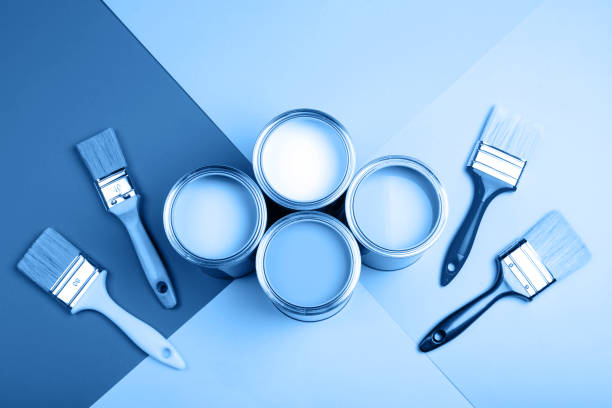 istock Four open cans of paint with brushes on bright background. 1193200156