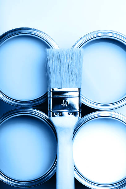 istock Four open cans of paint with brushes on bright background. 1193201068