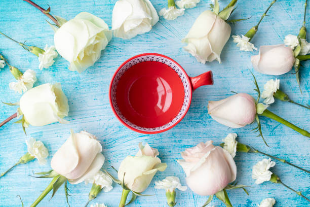 istock Cup of coffee surrounded by white roses 1193201853