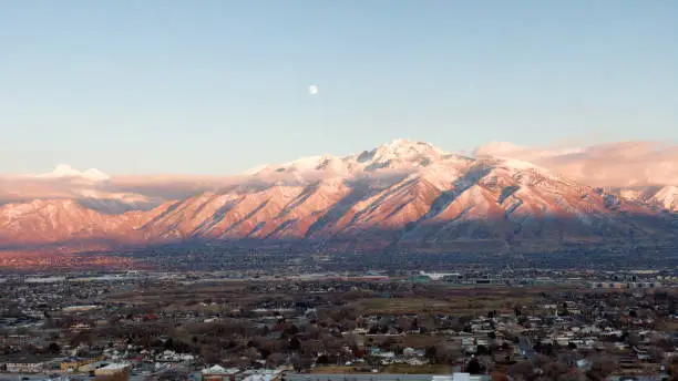 Drone shot of the Wasatch mountains with the moon overhead.