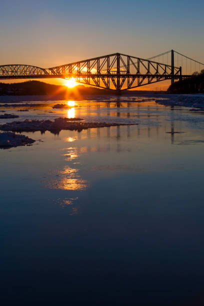sun setting behind quebec city bridge. - vertical lift bridge imagens e fotografias de stock