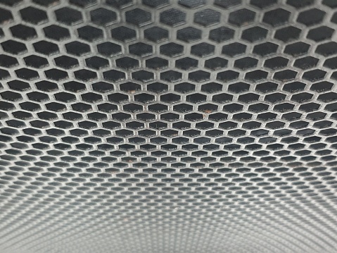 Metallic mesh part of microphone and loudspeaker. Combination of small dots background texture.