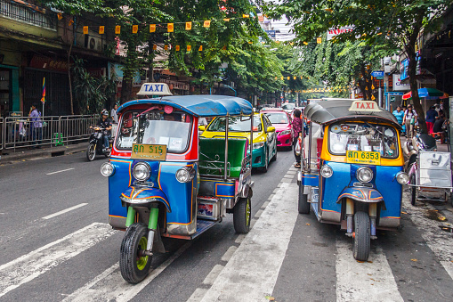 Bangkok, Thailand - October 26th 2013. Tuk tuks on a street in the city. This method of public transport is still popular.