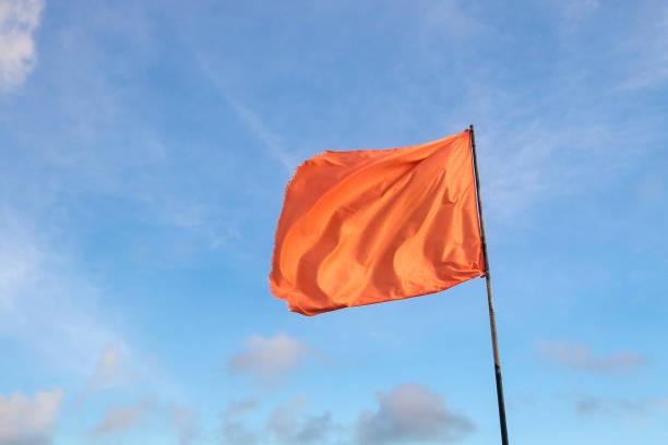 istock Waiving orange flag on a pole 1193216377