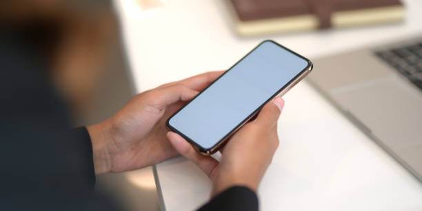 istock Close-up view of young businesswoman using blank screen smartphone while working on the project 1193216613