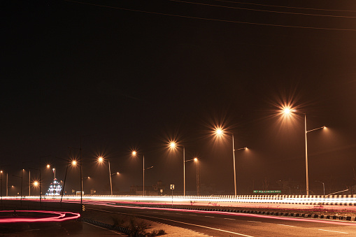 Nighttime city lights guiding the way: Driving on wet road among street lights. Elevated road under the path in Tampa, Florida