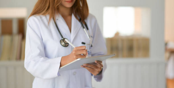 istock Cropped shot of young doctor checking patient chart while using digital tablet 1193220878