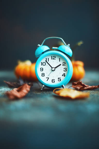 istock Time for Fall. Teal alarm clock with leaves and Pumpkins 1193220916