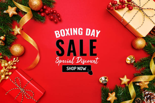 Boxing day sale with Christmas present and xmas decoration on red background Boxing day sale with Christmas present and xmas decoration on red background christmas human hand christmas ornament decoration stock pictures, royalty-free photos & images