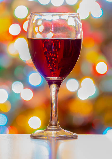 istock A Cup of wine with Christmas lights on the Background. Vertical view 1193227604