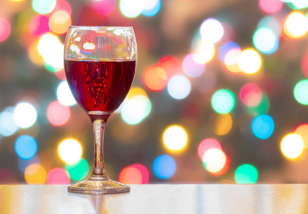 istock A Cup of wine with Christmas lights on the Background. Horizontal view 1193227606