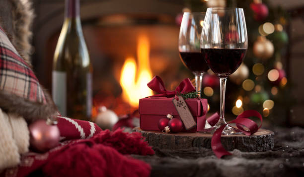vin rouge de noel devant la cheminée et l'arbre de noel avec des cadeaux - wine wine bottle bottle red photos et images de collection