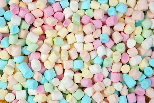 A bunch of small multi-colored Christmas marshmallows backgound. Isolated macro food