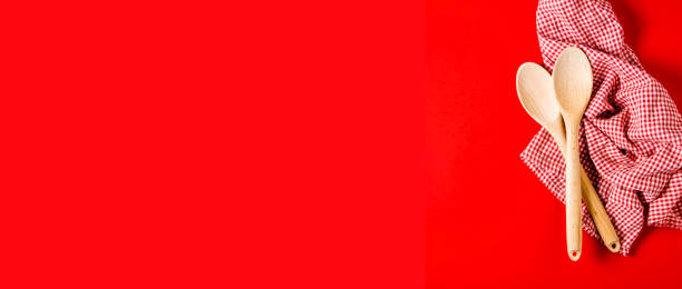 istock Kitchen textiles and wooden spoons on bright red background 1193232006