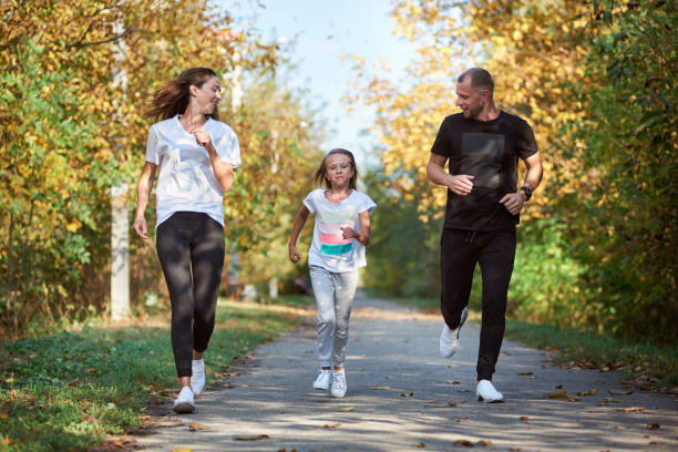 jogging de famille dans le stationnement - beautiful caucasian teenager running photos et images de collection