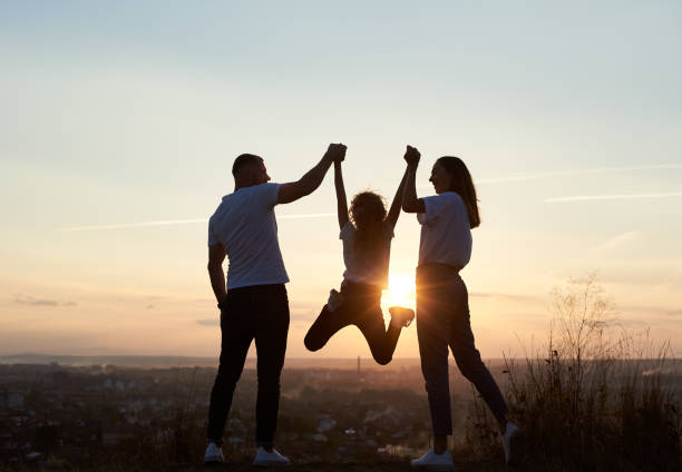 familia divirtiéndose juntos - holding hands child silhouette family fotografías e imágenes de stock