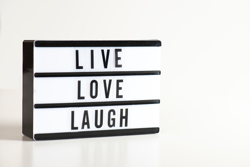 Live love laugh written in lightbox. Lightbox on the white background.