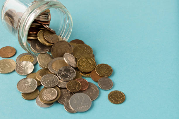 istock Various coins are scattered on a blue background. The concept of poverty. Selective focus. 1193238559