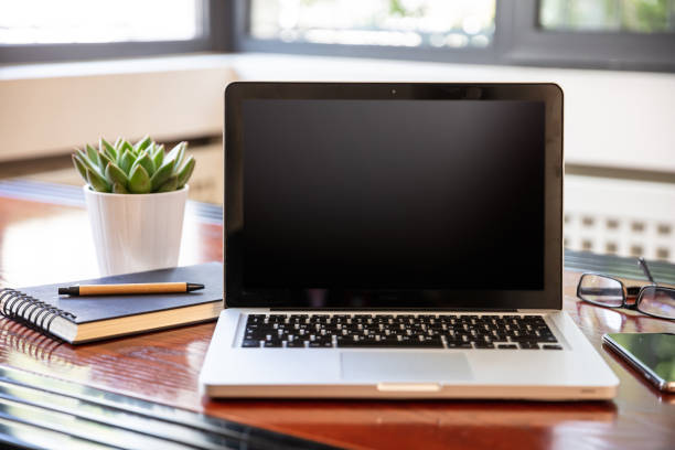 istock Laptop with black blank screen on a wooden desk 1193239315