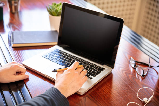 istock Laptop with black blank screen on a wooden desk 1193239318