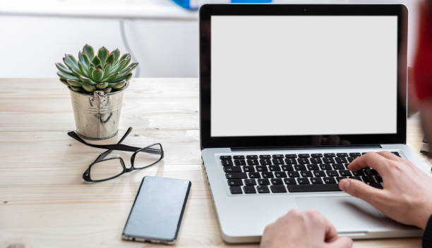 istock Laptop with white blank screen on a wooden desk 1193239346