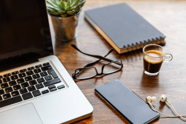 trabalho. portátil e telefone móvel do computador em uma mesa de escritório de madeira - cafe laptop espresso business - fotografias e filmes do acervo