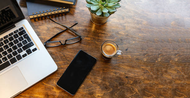istock Workplace. Computer laptop and mobile phone on a wood office desk 1193239357