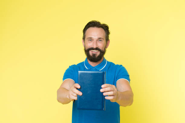 Literary critic. Man mature bearded guy hold book. Satisfied reader. Book presentation concept. Author presenting book copy space. Bestseller and book store. Literature taste and recommendations