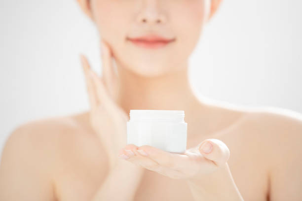 young woman holding moisturizer cream jar