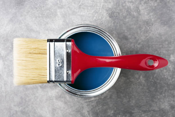 Can of paint with brush.