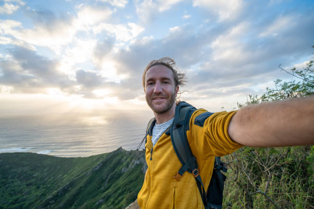 istock Young man hiking at sunrise taking selfie 1193252240