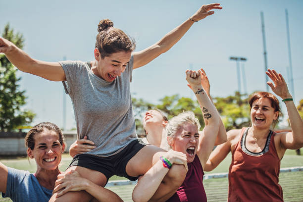 Women soccer players celebrating together Group of women, female soccer players together outdoors, celebrating victory. football player girlfriend stock pictures, royalty-free photos & images