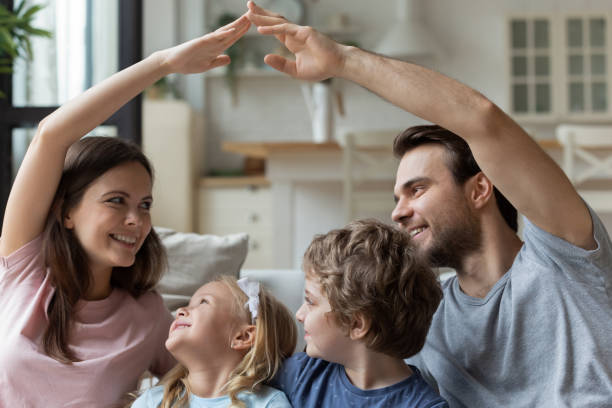 istock Smiling parents sitting with kids, making roof gesture with hands 1193254263
