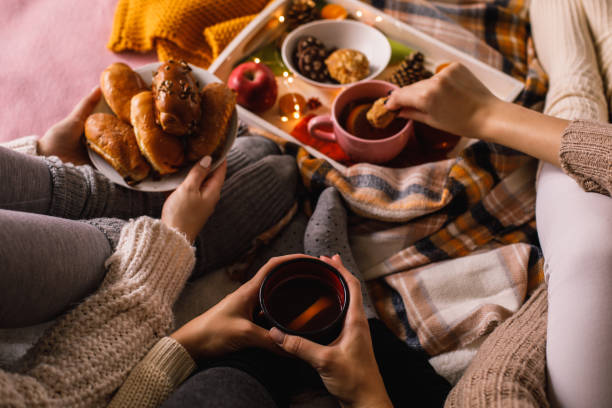 istock Unrecognizable girlfriends enjoying tea and delicious autumnal snacks 1193256478