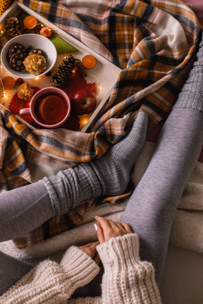 istock Unrecognizable young woman enjoying warm tea and snacks while relaxing on the bed 1193256484