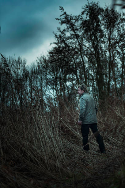 istock Man in jacket walking between reed in autumn. 1193258507