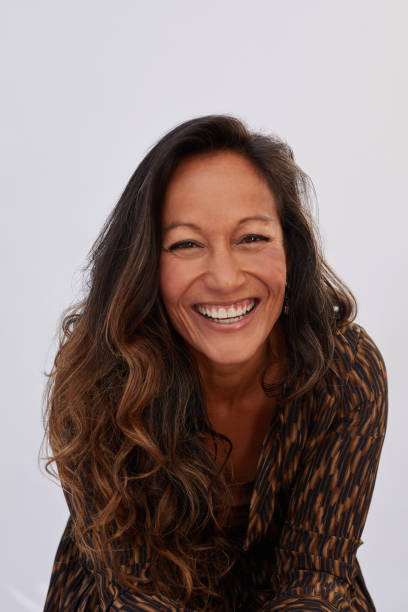 istock Mature woman laughing while sitting against a gray background 1193259213