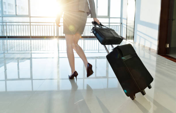 istock Businesswoman pulling a suitcase walking on corridor 1193259326
