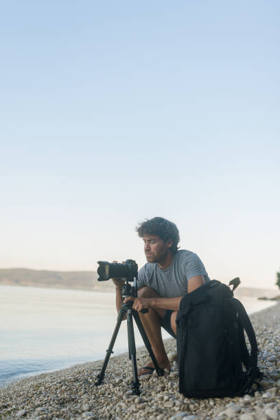 istock Male photographer setting up the camera on tripod 1193260816