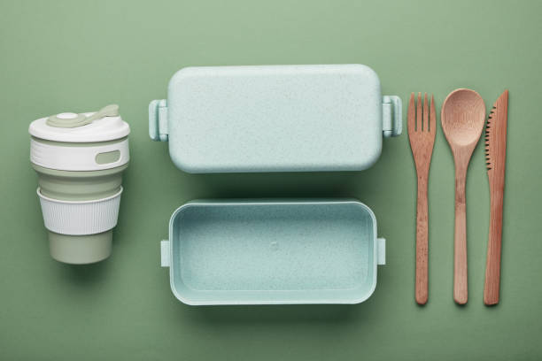 concetto di pranzo a rifiuti zero. tazza e scatola riutilizzabili, posate di bambù. posa piatta su sfondo verde - reuseable foto e immagini stock