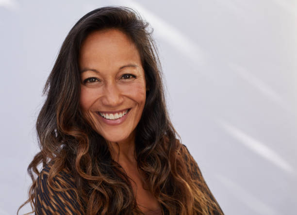 istock Mature woman smiling while standing against a gray background 1193262662