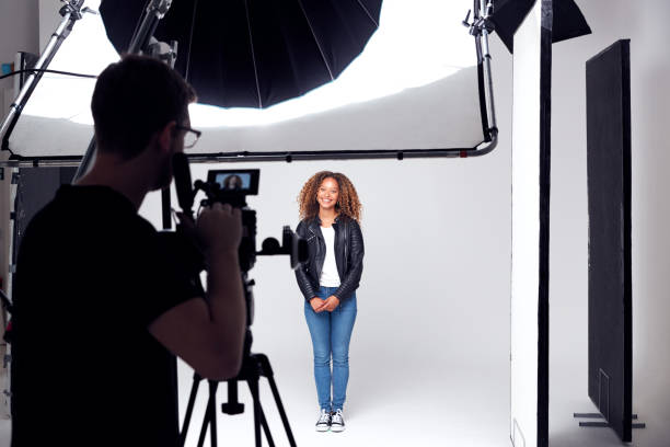 modèle féminin travaillant sur le plateau dans le studio photographique ou de film - séance photo photos et images de collection