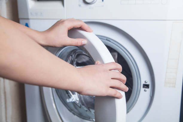 istock Hands opened the door of washing machine. 1193265171