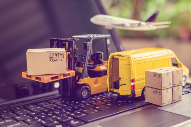 물류, 공급망 및 배송 서비스 개념 : 포크 리프트 트럭은 상자 판지와 팔레트를 이동합니다. 노트북 컴퓨터에 밴, 전자 상거래 인기 시대에 전 세계 제품의 넓은 확산을 묘사 - cargo container 이미지 뉴스 사진 이미지