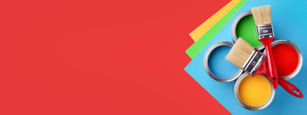 Cans of colorful paint on red background.
